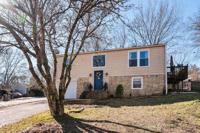 bi-level home featuring a garage and a front yard