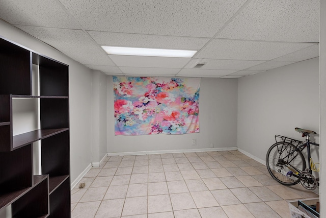 unfurnished room featuring a drop ceiling and tile patterned floors