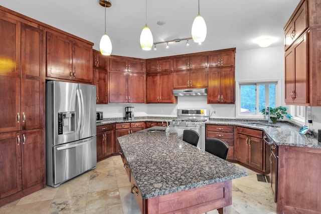 kitchen with pendant lighting, appliances with stainless steel finishes, sink, a center island, and dark stone countertops