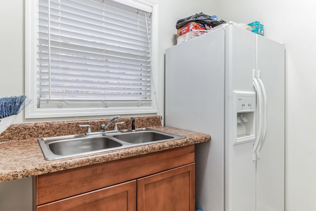 kitchen with white fridge with ice dispenser, plenty of natural light, and sink