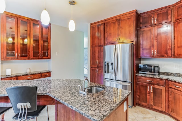 kitchen featuring sink, stainless steel appliances, a kitchen bar, and light stone countertops