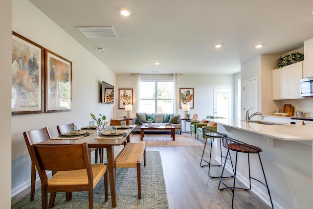 dining space with wood-type flooring and sink