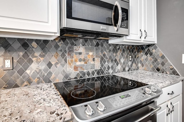 kitchen featuring white cabinets, appliances with stainless steel finishes, and tasteful backsplash