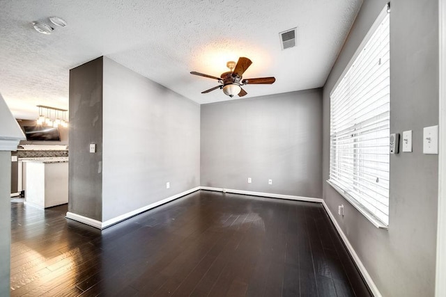 unfurnished room featuring ceiling fan, dark hardwood / wood-style floors, and a textured ceiling