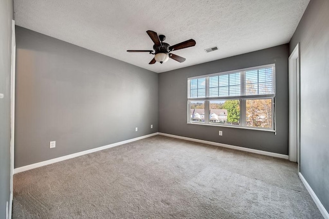 carpeted spare room with ceiling fan and a textured ceiling