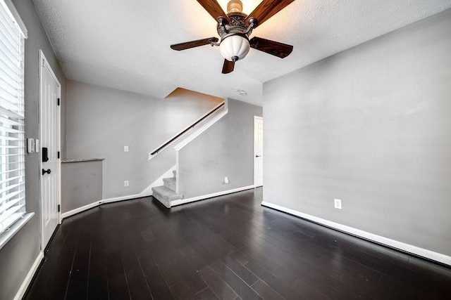 interior space featuring a healthy amount of sunlight, a textured ceiling, and dark hardwood / wood-style flooring