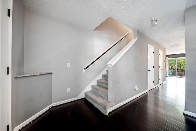 stairway featuring hardwood / wood-style floors and a textured ceiling