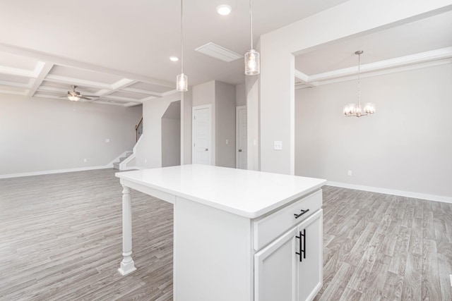 kitchen with pendant lighting, white cabinets, light hardwood / wood-style flooring, beam ceiling, and coffered ceiling