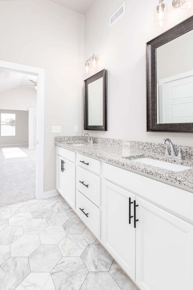 bathroom with vanity, ceiling fan, and vaulted ceiling