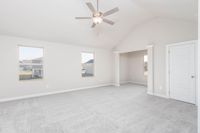 spare room with light colored carpet, vaulted ceiling, and ceiling fan