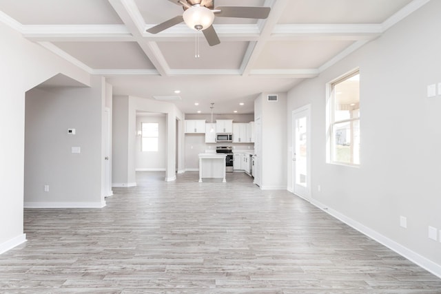 unfurnished living room featuring beam ceiling, a healthy amount of sunlight, and coffered ceiling