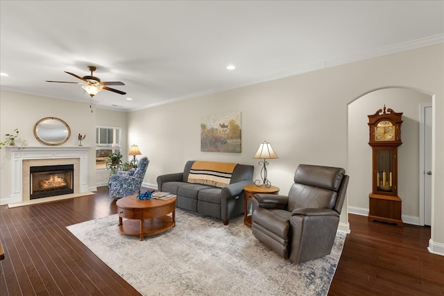 living room featuring ceiling fan, dark hardwood / wood-style flooring, and crown molding