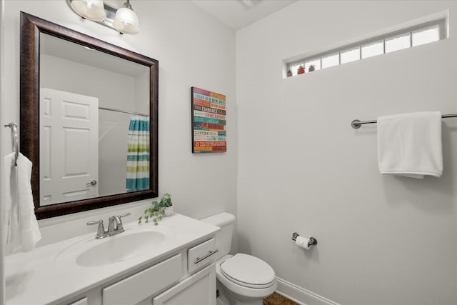 bathroom with curtained shower, toilet, and vanity