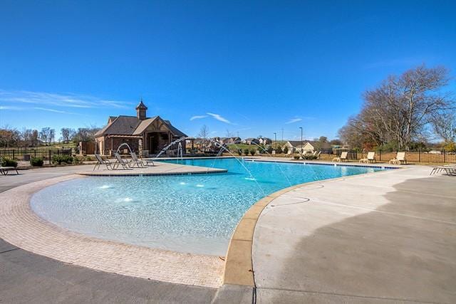 view of swimming pool with pool water feature and a patio