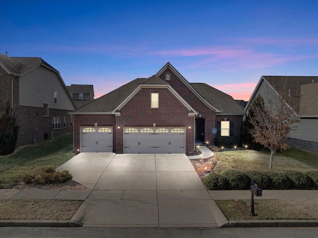 view of front of home with a garage and a lawn