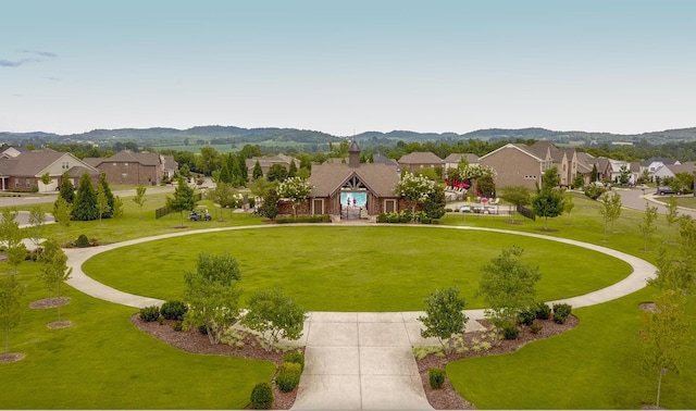 view of property's community featuring a mountain view and a yard