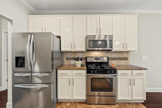 kitchen with ornamental molding, tasteful backsplash, dark stone countertops, and appliances with stainless steel finishes