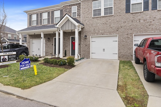 view of front of house featuring a porch, a garage, and a front yard