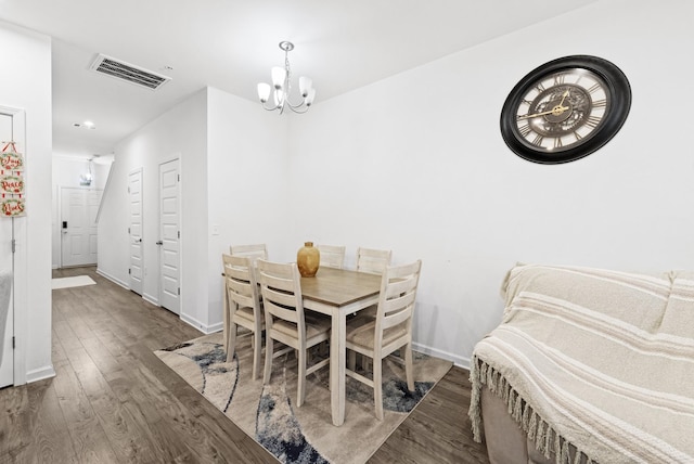 dining area featuring a notable chandelier and dark wood-type flooring