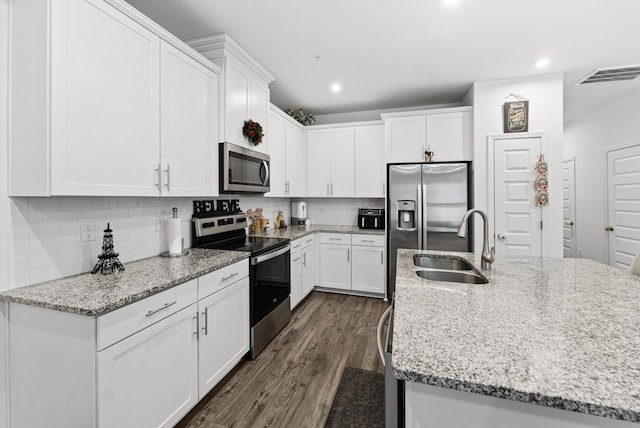 kitchen with sink, stainless steel appliances, dark hardwood / wood-style floors, light stone counters, and white cabinets