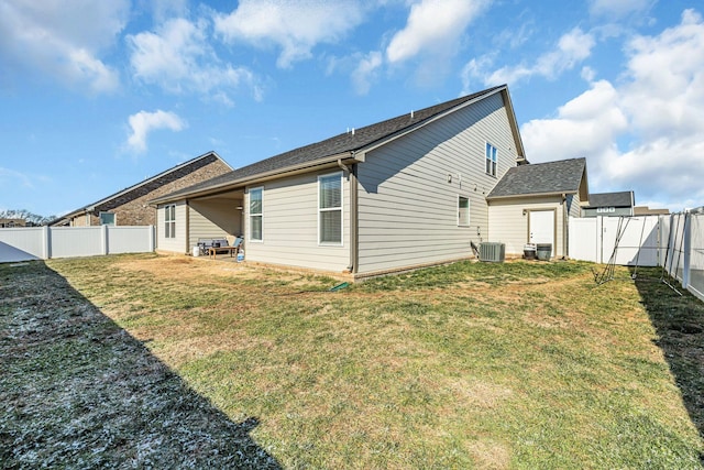 back of property featuring central AC unit and a yard