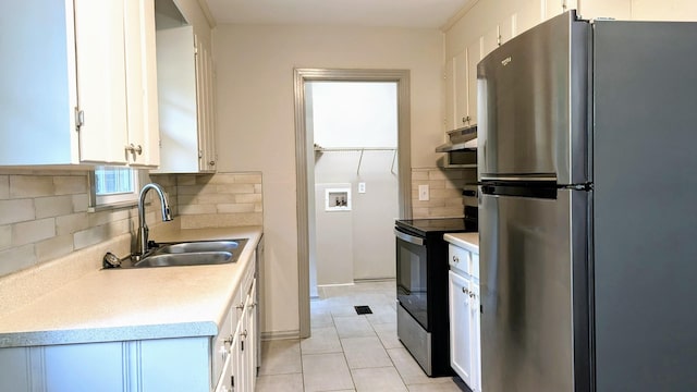 kitchen with white cabinets, appliances with stainless steel finishes, tasteful backsplash, sink, and light tile patterned floors