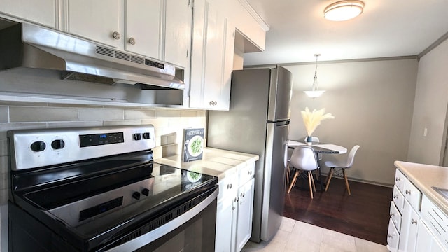 kitchen with decorative light fixtures, backsplash, white cabinets, and stainless steel appliances