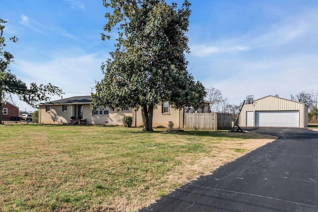 view of front of property with a garage, an outbuilding, and a front yard