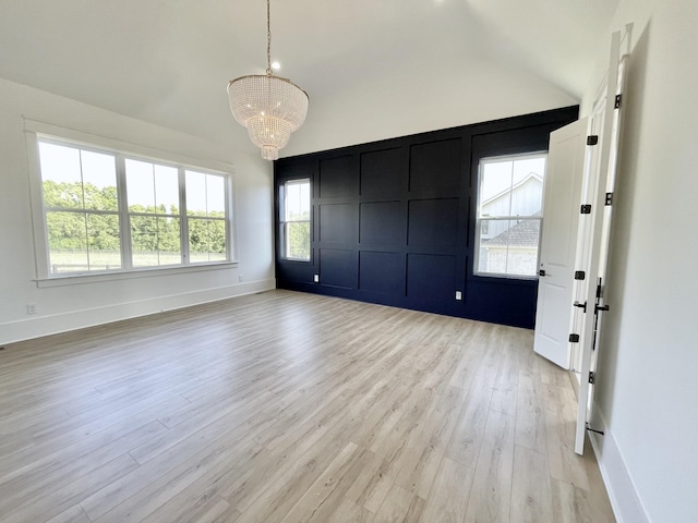 interior space with light wood-type flooring, a chandelier, and lofted ceiling