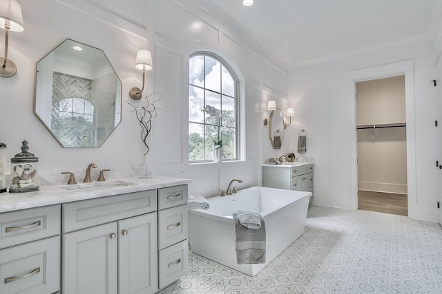 bathroom with crown molding, a washtub, and vanity