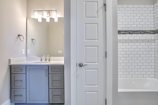 bathroom with tiled shower / bath combo and vanity