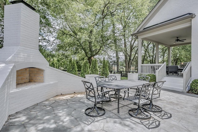 view of patio with an outdoor fireplace and ceiling fan