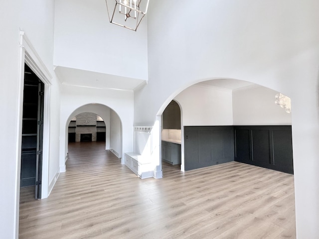 interior space with light hardwood / wood-style flooring and a towering ceiling