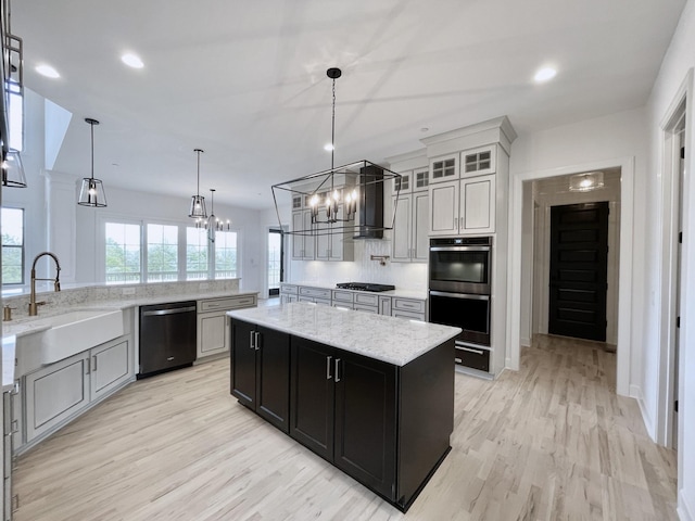 kitchen featuring light hardwood / wood-style floors, dishwasher, hanging light fixtures, sink, and a kitchen island