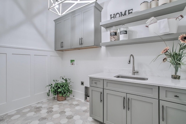 washroom featuring hookup for a washing machine, sink, cabinets, and hookup for an electric dryer