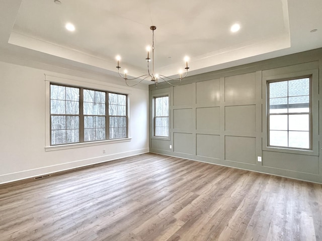 spare room with wood-type flooring and a raised ceiling