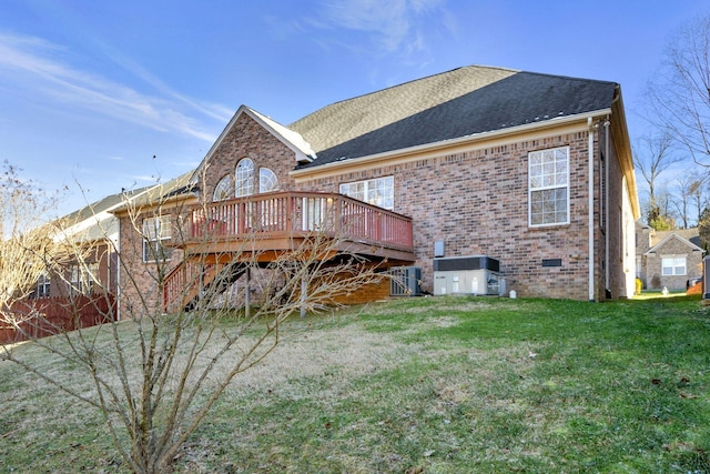 back of property featuring a wooden deck and a lawn