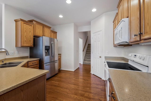 kitchen with sink, white appliances, and dark wood-type flooring