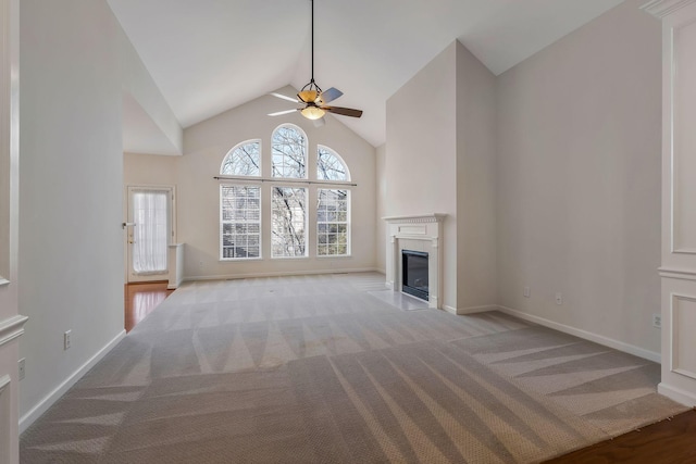 unfurnished living room with ceiling fan, light colored carpet, a high end fireplace, and lofted ceiling