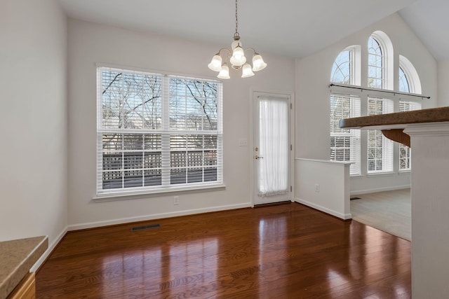 unfurnished dining area with dark hardwood / wood-style flooring and a notable chandelier