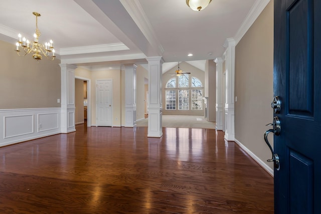 foyer featuring vaulted ceiling, ornate columns, ceiling fan with notable chandelier, dark hardwood / wood-style floors, and ornamental molding