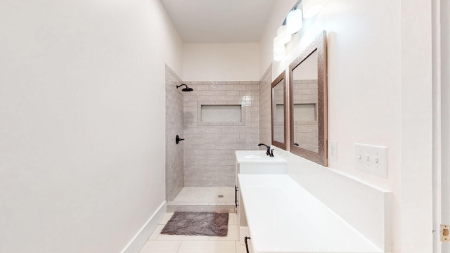 bathroom with tile patterned floors, tiled shower, and vanity