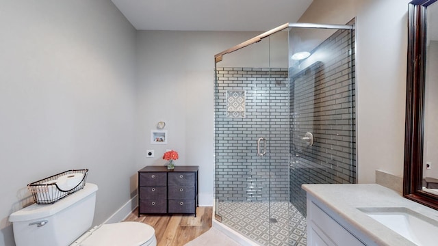 bathroom with wood-type flooring, a shower with door, toilet, and vanity