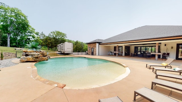 view of swimming pool with pool water feature and a patio area