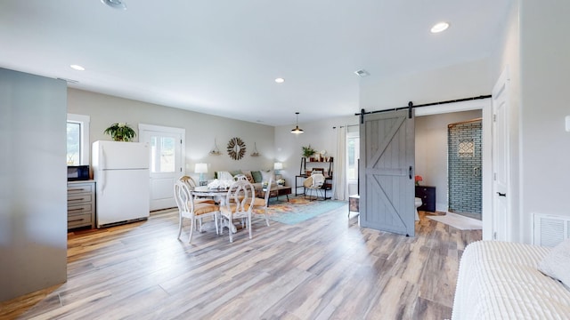 dining room featuring light hardwood / wood-style flooring and a barn door