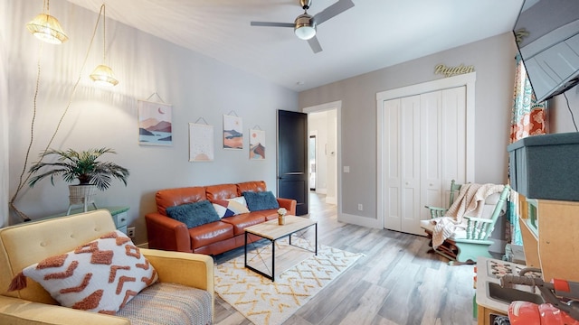 living room with light hardwood / wood-style floors and ceiling fan