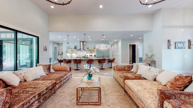 living room featuring a high ceiling, light hardwood / wood-style flooring, and a chandelier