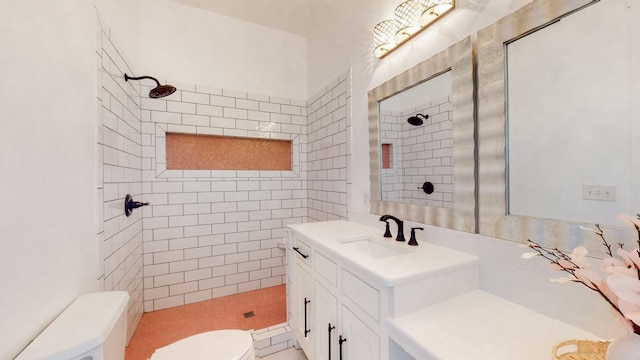 bathroom with tiled shower, toilet, and vanity