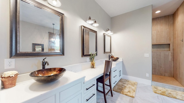 bathroom with tile patterned floors, tiled shower, and vanity