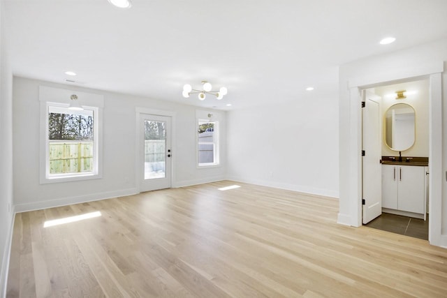 interior space with sink, plenty of natural light, and light wood-type flooring